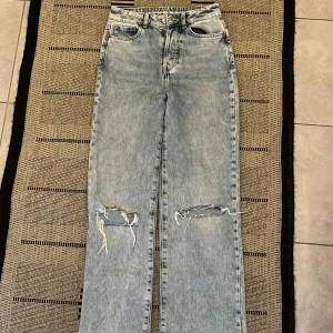 Blåa Jeans med hål (Bikbok) - Blåa jeans från bikbok med hål/slitningar, nästan aldrig använt,stl 25 Säljer för 150kr