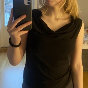Svart blus - Svart ”hängig” blus i stretchigt material. Det står M på lappen men skulle säga att det är mer XS/S (antar att det är utländsk storlek). Mycket bra skick🤩Pris kan diskuteras. Säljer pga inte min stil