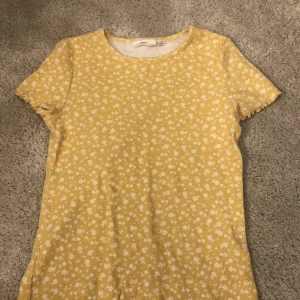 KappAhl tröja I storlek 134/140 - En gul med vita guliga blommor på! Väldig somrig och gulig!