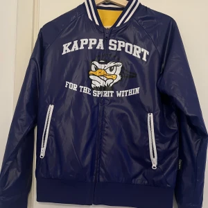 Varsity jacka från Kappa  - Jackan har två olika sidor som man kan använda. Jackan är i god skick och är i storlek S. Kontakta säljaren för fler information. Tar bara emot swish! Köparen står för frakten! 