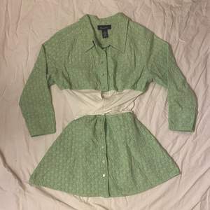 Matchande grön skjorta och kjol med blommmönster. Knytning i kjolen och skjortan i midjan 