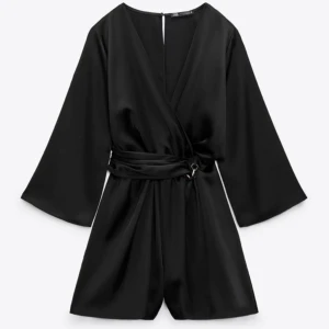 Svart jumpsuit - Säljer denna otroligt fina jumpsuit från zara i satin då den tyvärr inte satt som jag ville😔Helt ny med prislapp kvar. Jättesnygg tillsammans med tex svarta strumpbyxor och boots🤩