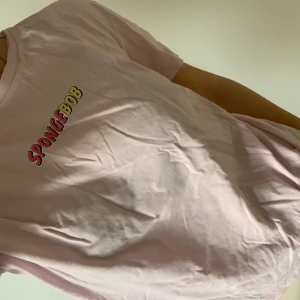 Spongebob T-shirt - Mjuk rosa Tshirt med coolt Spongebob print över ryggen. Ostrykt men i fint skick. Oversized, storlek S.