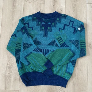 VINTAGE ADIDAS STICKAD TRÖJA 80-tal - Äkta stickad adidaströja.  Storlek mens L (50) sitter snyggt oversized på mig som är en strl 36/38. Mått:  Längd: 66cm Bröstbild: 69cm  Material: 47% akryl  29% bomull  24% viskos