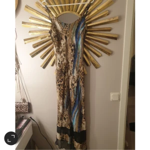 Klänning  - Mönstrad klänning, köpt utomlands. Står ingen storlek men skulle säga en medium ungfär, den är strechig i tyget.