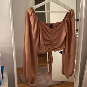 Topp - Dammrosa ribbad topp med justerbar scrunch i mitten och mesh armar. Storlek s. 