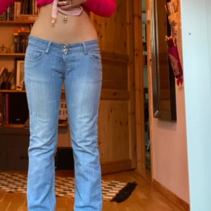 2000s Flared/bootcut jeans - Skitsnygga 90s 2000s bootcut jeans från ’Seyoo Jeans’. Supersöta kristall detaljer på knapparna och där bak. Tyget är supersnyggt och nästan lite randigt.  Jag kan mötas upp eller frakta. Storlek: 40. Midjemått: 85cm. Innerbenslängd: 80cm. 