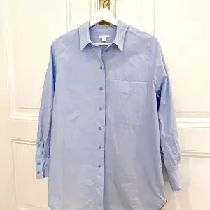 Snygg blå skjorta från Cos i 100% bomull och lite hårdare struktur. Oversized.   Skjortan är i mycket bra skick!   Köptes förra året, nypris 890 sek. 