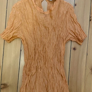 Tajt Top  - Skrynklig och läcker top i kaxig färg som passar såväl till fest som till vardags.  Storleken är i plagget är angiven som 42 men jag anser att det mer är en 40. 