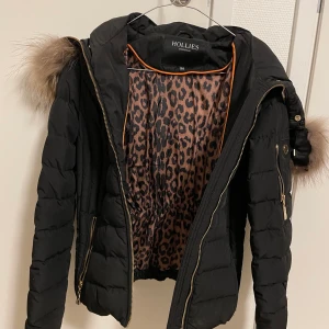 Hollies vinterjacka size 34 - Svart dunjacka i storlek 34 med avtagbar krage. Den är nästintill oanvänd och i bra skick. 