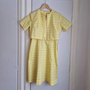 En helt fantastisk vintageklänning i citrolgul färg (klarare än på bilderna). En av de finaste jag har i min ägo.  Tillhörande jacka. Bomull.  Passar gissningsvis stl 36/38/S/M. Midjemått, mätt tvärs över: 40 cm.