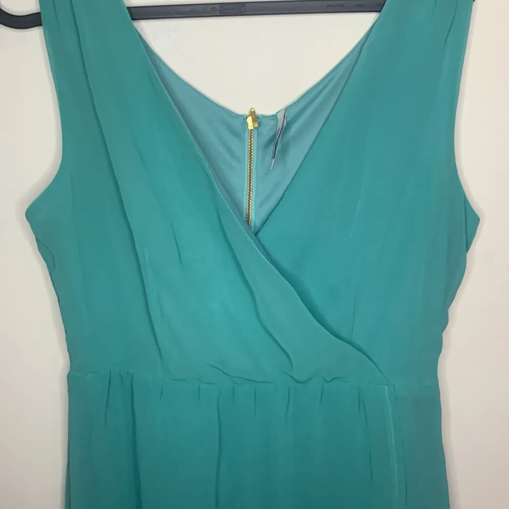 Färgen på klänningen är turkos blå nästan grön kan man säga, den är underbar och ser ut som en wrap-topp tillsammans med en luftig kjol! Du får den nu 50% off. Klänningar.