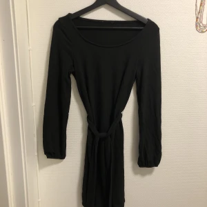 Långärmad svart klänning - Från NA-KD i strl XS. Använd en gång. Låga axlar.