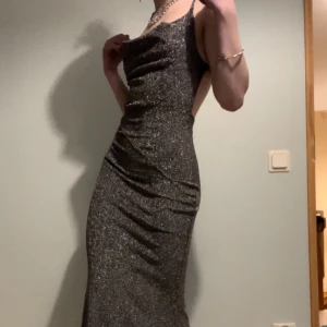 Balklänning  - Använd 1 gång, silvrig/glittrig   Jag är 165cm och den går ner till marken