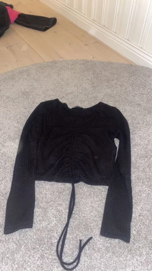 Långärmad topp  - Svart långärmad topp med snörning i mitten, bra skick