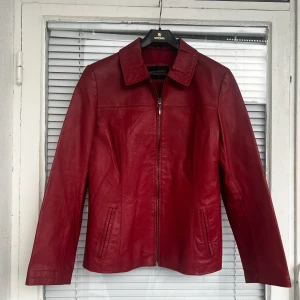 RÖD LÄDERJACKA - Läderjacka i fint skick säljes. Äkta läder strl: 40, upplevs dock som en M. Pris: 350 kr, kan fraktas för 69 kr (spårbart) som köparen står för, vid snabb affär kan priset diskuteras. 