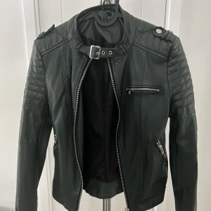 Skinnjacka  - Trendig mörkgrön skinnjacka i storlek S men skulle mer säga XS. Knappt använd.