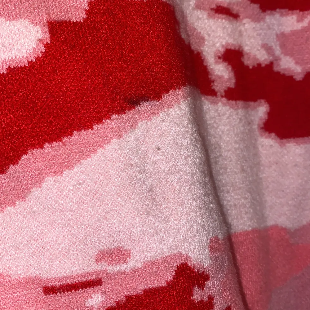 Rosa/röd mönstrad stickad tröja, tyvärr en liten fläck där av billigt pris. . Stickat.