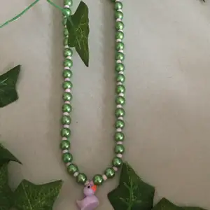 Gröna och små råsa pärlor med en anka i mitten, kabinhake.