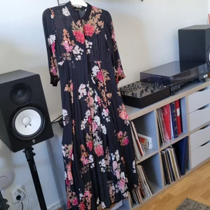 Zara långklänning med fickor. Stl M - Säljer denna superfina långklänning från Zara med knappar hela vägen framtill pga för liten över bysten på mig. Inköpt i Spanien för ca 5 år sedan. Den har fickor och är gjord i ett tunt och lufrigt bomullstyg. Har en rak söm under bysten och själva kjolen är sydd i flera partier vilket ger ett otroligt fint fall. Det är en sorg att denna ej passar mig då den är så vacker. Använd endast ett par gånger. Köpare betalar frakt.