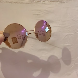 Solglasögon  - Ett par runda solglasögon.