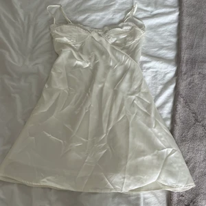 Satinklänning  - Säljer en klänning jag köpte på Plick för länge sen men som inte kommer till användning. Bra skick och använd en gång. Står tyvärr inte vart klänningen är ifrån då lappen är borta. Köparen står för frakt 