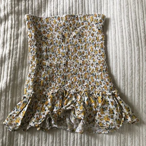 Blommig minikjol - Super söt blommig kjol som även går att använda som topp från Bershka. I strlk XS/S. Använd fåtal gånger så i helt nyskick. 