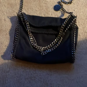 Väska - Säljer denna Stella liknande väskan som jag har haft i 2 år ca men har inte använt det senaste året💓 Köpte för 500 men säljer för 400 ca inte använd så mycket och ett litet hål uppe i hörnet dock men inte satt man ser