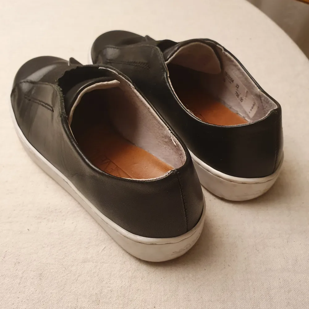 Stilrena svarta sneakers i 100% läder gjorda i Spanien.  Originalpris: 798 kr Skick: som nya, väldigt sparsamt använda.. Skor.