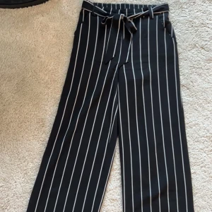 Byxor - Randiga byxor från only storlek 36 i mycket gott skick. Dekorativt band runt midjan som man kan knyta både fram och baktill plus fickor på båda sidorna