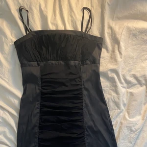 Cocktail klänning  - En svart cocktail klänning med 90-tals vibe. Perfekt skick, köpt på sellpy men är för stor för mig i midjan och även lite längre än förväntat . Klänningen har Justerbara band och är gjort i silkliknande  material.  pris kan diskuteras, frakt 49kr. 