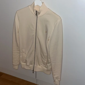 Farah zip tröja - En zip tröja får märket Farah och är i färgen cream och är i stl xxs använd några gånger men ser helt ny ut. Ny pris 879kr