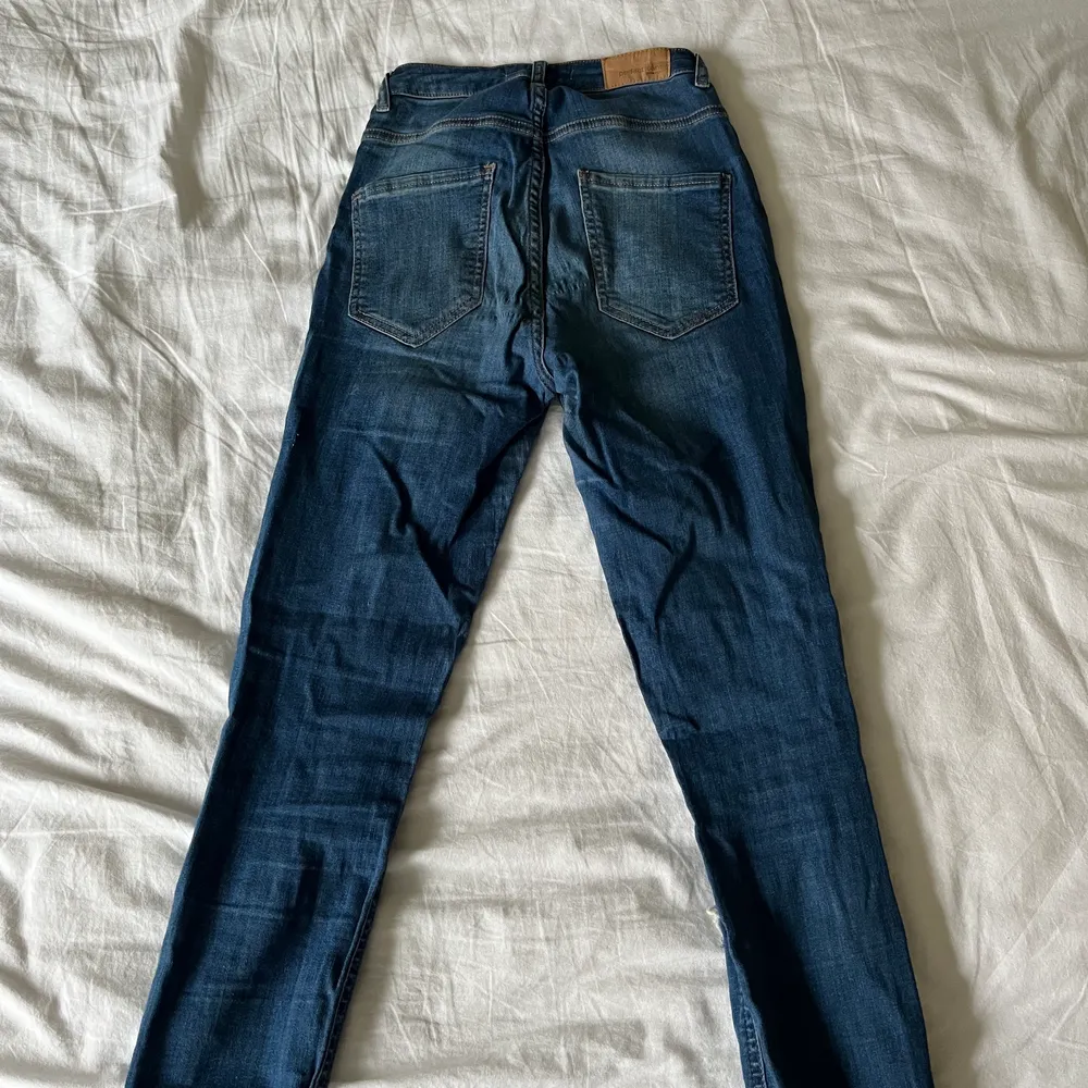 Ett par blåa slim jeans med slitningar från Ginatricot i storlek M.. Jeans & Byxor.