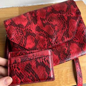 Röd ormskinnsmönstrad handväska med matchande plånbok från Monki