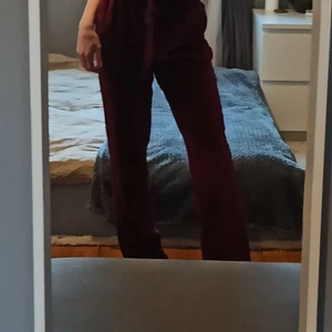 Vinröda velourbyxor  - Vinröda velourbyxor i storlek M. Säljer så de är för stora för mig. Bilden ger inte färgen rättvisa men byxorna är liknande den färgen (se på bild 3)