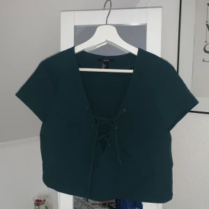 Crop top i smaragdgrön färg med snöre - Supersöt top i emerald färg med snörning. 