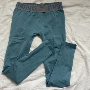 Gymshark  - Gymshark byxor i blå & grå band! Sitter super bra på och skön att ha på sig. Använd 1 gång! 