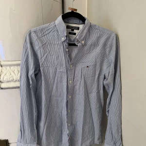 Tommy Hillfiger skjorta  - Randig Tommy Hillfiger-skjorta i herrefolken, size S. Runt tyg. Passar en kvinna. Slim fit herrmodell.
