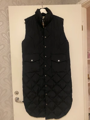 Lång vöst - En supersnygg lång väst från märket FREEQUENT i storlek S men upplever att den är lite stor i sin storlek. Använd ett fåtal gånger och är som ny!   Köpes för 800 kronor