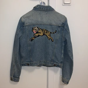 Jeanjacka med tigerbroderi i ryggen  - Cool jeansjacka med tigerbroderi i ryggen. Bra skick!