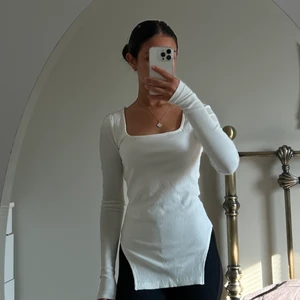 Vit urringad tröja med slit - Säljer denna fina långärmade tröjan från Na-kd! Endast använt en gång. Jag är 160 cm lång och bär storleken XS. Köparen står för frakten🤍
