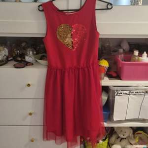 En röd klänning med stor röd eller silver hjärta Storlek: 146/152cm