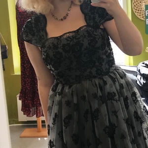 Elegant svartblommig klänning - Så så så fin klänning som jag hade på min bal i år! Köpt i en secondhandbutik men helt sjukt bra skick. Den sitter tight som en korsett i överdelen och går nedanför knäna på mig som är 166 cm. Köparen står för frakten!🕺🏼👻