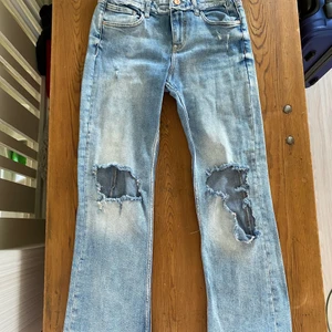 Håliga jeans - Ett par lågmidjade zara jeans med hål i knäna.
