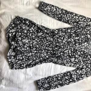Jumsuit  - En svart jumpsuit med vita blommor 