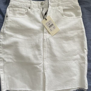 Vit jeanskjol  - Helt oanvänd vit jeanskjol med en liten slits längst ner. 