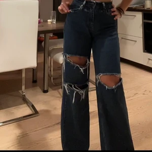 Mörkblå jeans med slitningar storlek 36 - Dessa byxor har jag haft i knappt ett år och det är mina favoriter. Anledningen till att jag säljer dem är för att de har blivit för små. Storleken är 36 och de är i bra skick. Skriv om ni har några frågor!