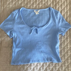 babyblå topp - Jättefin babyblå topp med knytning från monki som tyvärr inte längre kommer till användning. Jättefint skick och perfekt nu till sommaren🧃💕