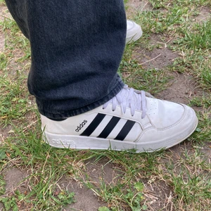 Adidas sneakers vita - Vita adidas skor med svarta stripes, sitter bra på foten men används inte längre. Något skitiga men det är inget en tvätt inte kan fixa, storlek 44 2/3🥳