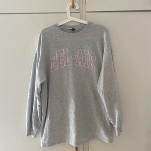 Grå Sweetshirt  - Grå sweetshirt med lila tryck från h&m. Storlek s dock väldigt stor i storleken. Säljs pga att den inte längre kommer till användning.